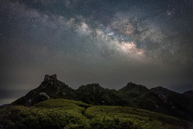 night time sky with a mountain background showing starry night