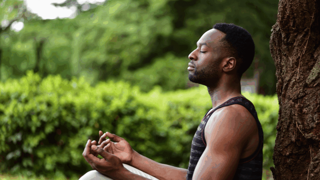 man sitting and meditating in nature