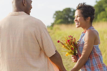 man and woman holding hands. The woman is holding flowers