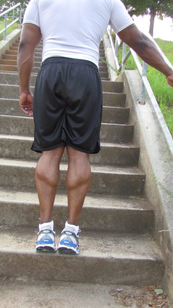 man doing calf raises using stairs